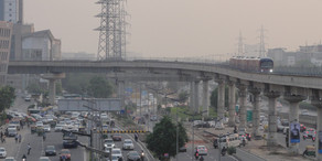 Foto einer großen Straße mit überirdischer Metro in einem Vorort von Delhi in Indien