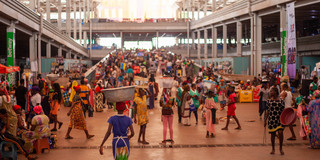 There is a market in the global south. There are people walking around with goods on their heads, balancing them