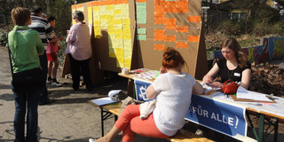The picture shows a charette procedure, people sitting in front of a partition wall