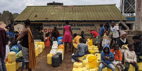 Kibera, Nairobi, Kenia Viele Leute mit Wassercontainern, die vor einem neu errichteden Wasserkiosk im Stadtteil Kibera in Nairobi warten