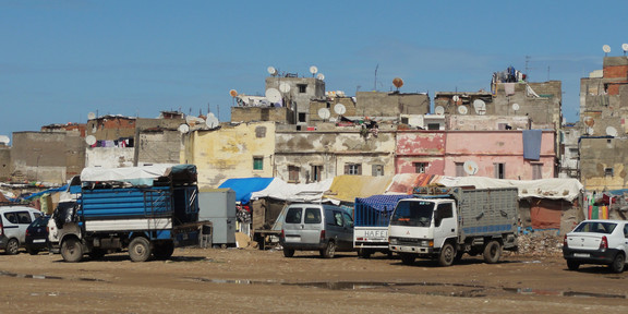 Mehrere Lastwägen vor Wohngebäuden in der Altstadt von Casablanca