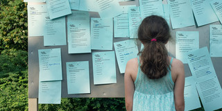 Mädchen vor Pinnwand mit Zetteln als Teil des INTERPART Projektes in Berlin