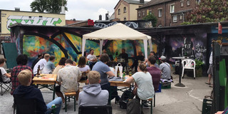 Mehrere Personen auf Stühlen, die an einer Diskussionsrunde zum Abschluss eines Studierendenprojekts zu Trinkhallen in Dortmund teilnehmen