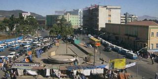 viele Leute an einer großen Straße in Addis Abeba. Viele Leute sind am Straßenrand. Einige verkaufen dort Sachen. 