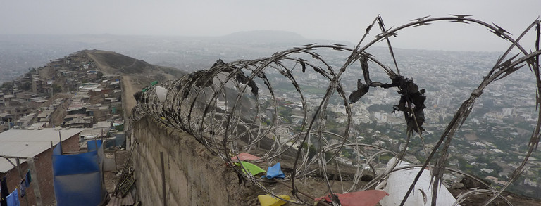 A wall with barbed wire in the city of Lima in Peru