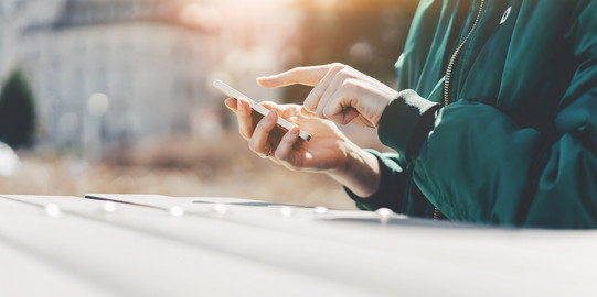 Person tippt etwas auf einem Smartphone ein